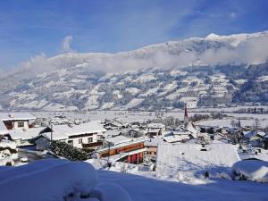 a town covered in snow with a mountain in the background at Chalet in Fügen near Spieljoch Ski Lift in Fügen
