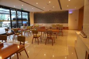 a restaurant with tables and chairs and a chalkboard at 7 Days Premium Chongqing Longtou Temple North Railway Station Center in Chongqing
