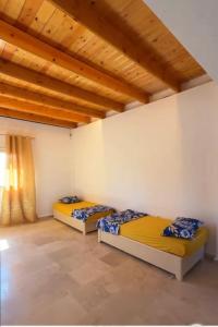 two beds in a room with wooden ceilings at Sarl piscine chaufente familial in Alger