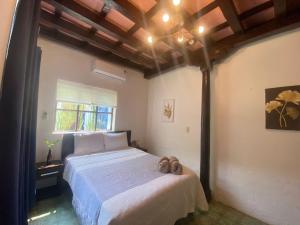 une chambre avec un lit avec deux chaussures dessus dans l'établissement Casa Cristal, à Chiapa de Corzo