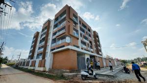 a building with a scooter parked in front of it at Suvarna Millennium Suits in Mysore