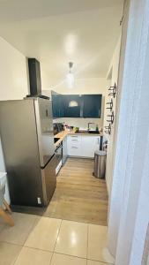 a kitchen with a stainless steel refrigerator and wooden floors at Chambre d hotes Marseille Prado in Marseille +17 photos