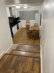 Una cocina y un comedor con una mesa y un refrigerador. en Rusholme Rooms, en Mánchester
