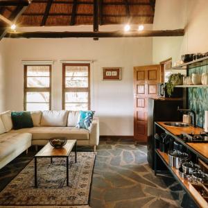 a living room with a couch and a table at Rosemary Hill Farm in Pretoria