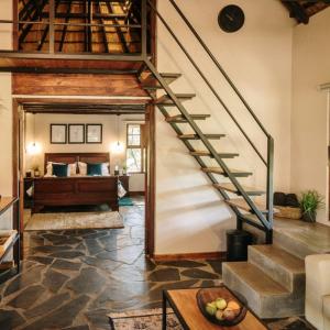 a staircase in a living room with a bed at Rosemary Hill Farm in Pretoria
