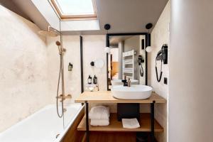 a bathroom with a sink and a tub and a mirror at Villa Kerasy Hotel Spa in Vannes