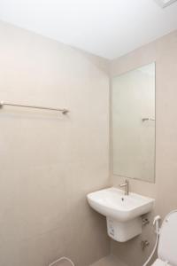a white bathroom with a sink and a mirror at Timber Hotel in Ban Bang Rathuk