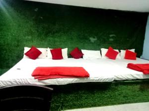 a large bed with red and white pillows on it at Hotel Shree Krishna Nearby Bhubaneswar Railway Station in Bhubaneshwar