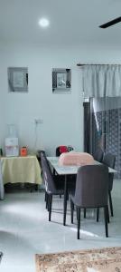 een eetkamer met een tafel en stoelen bij Bait al-Qamar in Kampong Wakaf Tengah +6 foto's