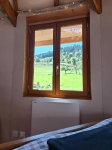 a window in a bedroom with a view of a field at Le Repaire de Mitzerlé in Mitzach