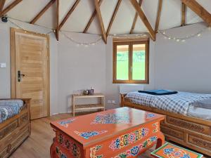 a bedroom with two beds and a table in it at Le Repaire de Mitzerlé in Mitzach