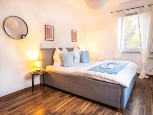 コー​​ブルクにあるGreenTreeHomes - Herzstück Kirsche- im Zentrum Coburgsの壁に鏡が付いた大きなベッドのある寝室