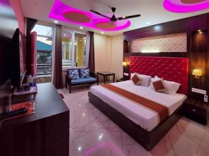 a bedroom with a large bed with a red headboard at Amoda - Best Hotel in Dharamshala in Dharamshala