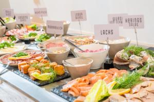 a buffet filled with different types of seafood and vegetables at Das Oswald's Boutique Hotel in Cuxhaven