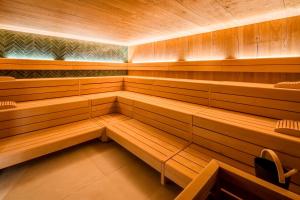 a sauna with wooden benches and chairs in it at Das Oswald's Boutique Hotel in Cuxhaven