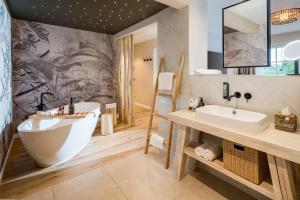 a bathroom with a large tub and a sink at Das Oswald's Boutique Hotel in Cuxhaven +102 photos
