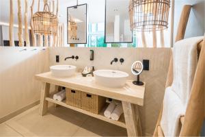 a bathroom with two sinks and a mirror at Das Oswald's Boutique Hotel in Cuxhaven