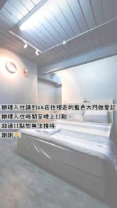 Una habitación con una cama con escritura en la pared. en 新橙居, en Dalin