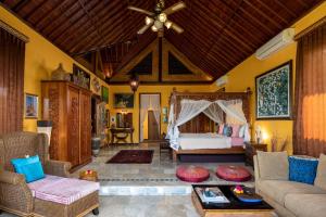 a living room with a bed and a couch at Villa Air Terjun Bucuan in Sukawati +18 photos