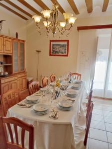 a dining room with a long table with chairs and a chandelier at Casa MI LUCÍA in Moratalla