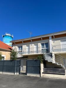 a house with a black gate and stairs and a lighthouse at Charmant duplex Audenge in Audenge +7 photos