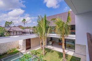 PererenanにあるVilla Shanaya Pererenanのヤシの木が植えられた家の外観