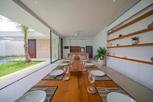PererenanにあるVilla Shanaya Pererenanの長いダイニングルーム(テーブル、椅子付)