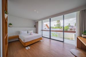 PererenanにあるVilla Shanaya Pererenanのベッドと大きな窓のある寝室 +14枚の写真