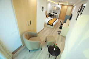 een kleine hotelkamer met een bed en een stoel bij Stay Luxurious in Jaipur