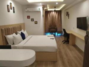 een hotelkamer met een groot bed en een bureau bij Stay Luxurious in Jaipur