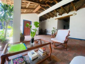 a living room with a glass coffee table and a white chair at Casa Cristal Habitación Andromeda in Chiapa de Corzo