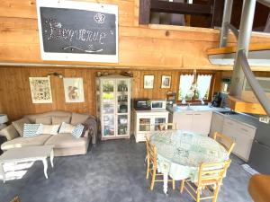 een keuken en woonkamer met een tafel en een bank bij Maison avec jardin à TREGASTEL REF 55 in Trégastel