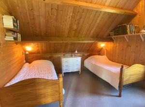 twee bedden in een kamer met houten wanden bij Maison avec jardin à TREGASTEL REF 55 in Trégastel