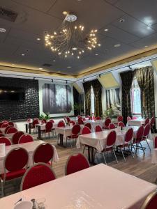 a banquet hall with tables and chairs and a chandelier at Hotel Paffhausen in Wirges