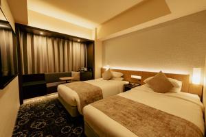 a hotel room with two beds and a couch at Hotel JAL City Sapporo Nakajima Park in Sapporo