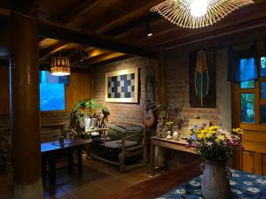 ein Wohnzimmer mit Tisch und Stühlen und Fenstern in der Unterkunft Pham's House - Homestay & Cafe in Sa Pa