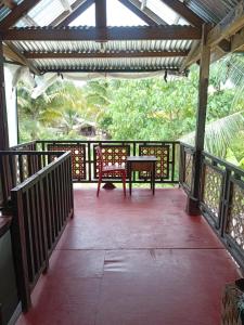 een veranda met een tafel en een bank erop bij Kubo ni klay in San Isidro