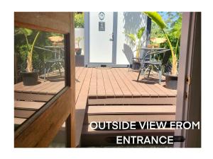 an open door to a patio with tables and chairs at The Olive Room on Gallery Walk in Mount Tamborine