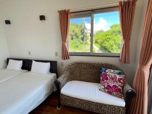 a room with two beds and a chair and a window at シーブリーズ古宇利 in Nakijin +13 photos