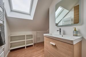 a bathroom with a sink and a mirror at Les tuiles bourguignonnes in Fontaine-lès-Dijon
