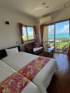 a bedroom with two beds and a view of the ocean at シーブリーズ古宇利 in Nakijin