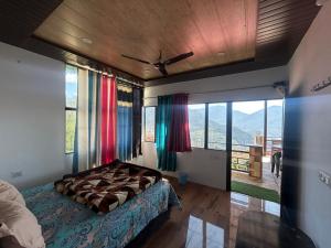 Un dormitorio con una cama en una habitación con ventanas. en hotel first view, en Chopta