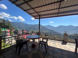 - Balcón con mesa y sillas y vistas a las montañas en hotel first view, en Chopta