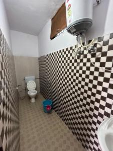 baño con pared a cuadros en blanco y negro en hotel first view, en Chopta