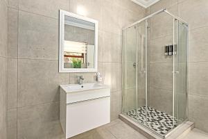a bathroom with a shower and a sink and a mirror at Shai in Johannesburg +13 photos