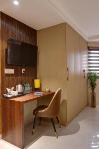 a room with a desk with a chair and a television at Hotel Deluxe Stay Inn Delhi Airport in New Delhi +101 photos