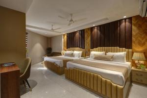 a hotel room with two beds and a desk at Hotel Deluxe Stay Inn Delhi Airport in New Delhi