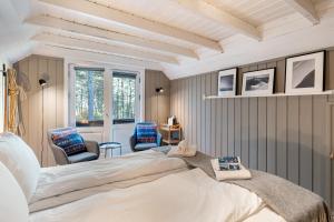 a bedroom with a large bed and two chairs at Herangtunet Mountain Lodge in Heggenes