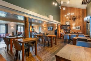 a restaurant with wooden floors and tables and chairs at Herangtunet Mountain Lodge in Heggenes