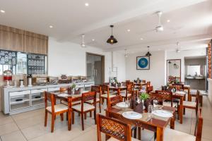 a restaurant with wooden tables and chairs and a kitchen at Royal Paris in Chennai +17 photos
